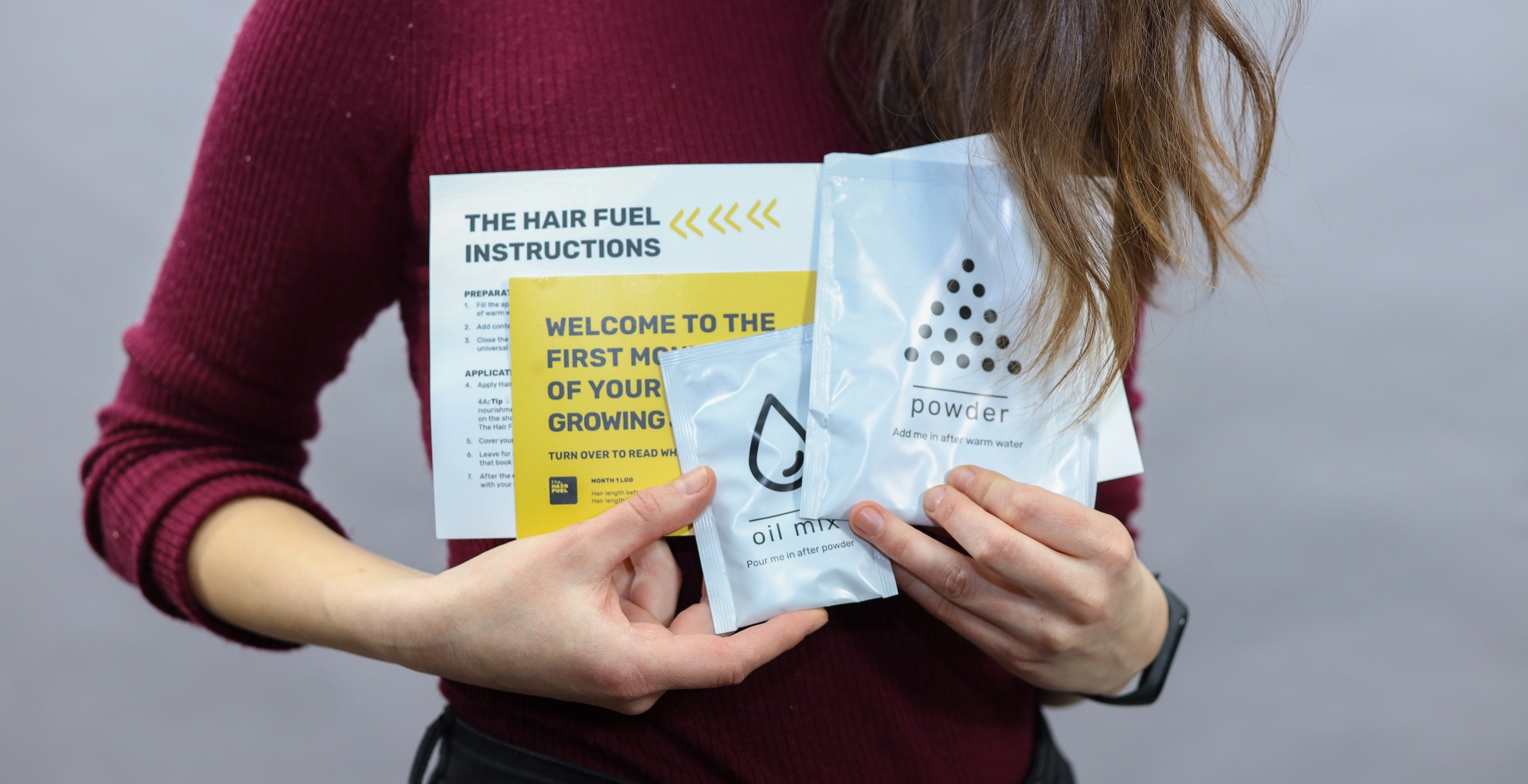 Person holding a yellow leaflet and two white packets with text and branding.