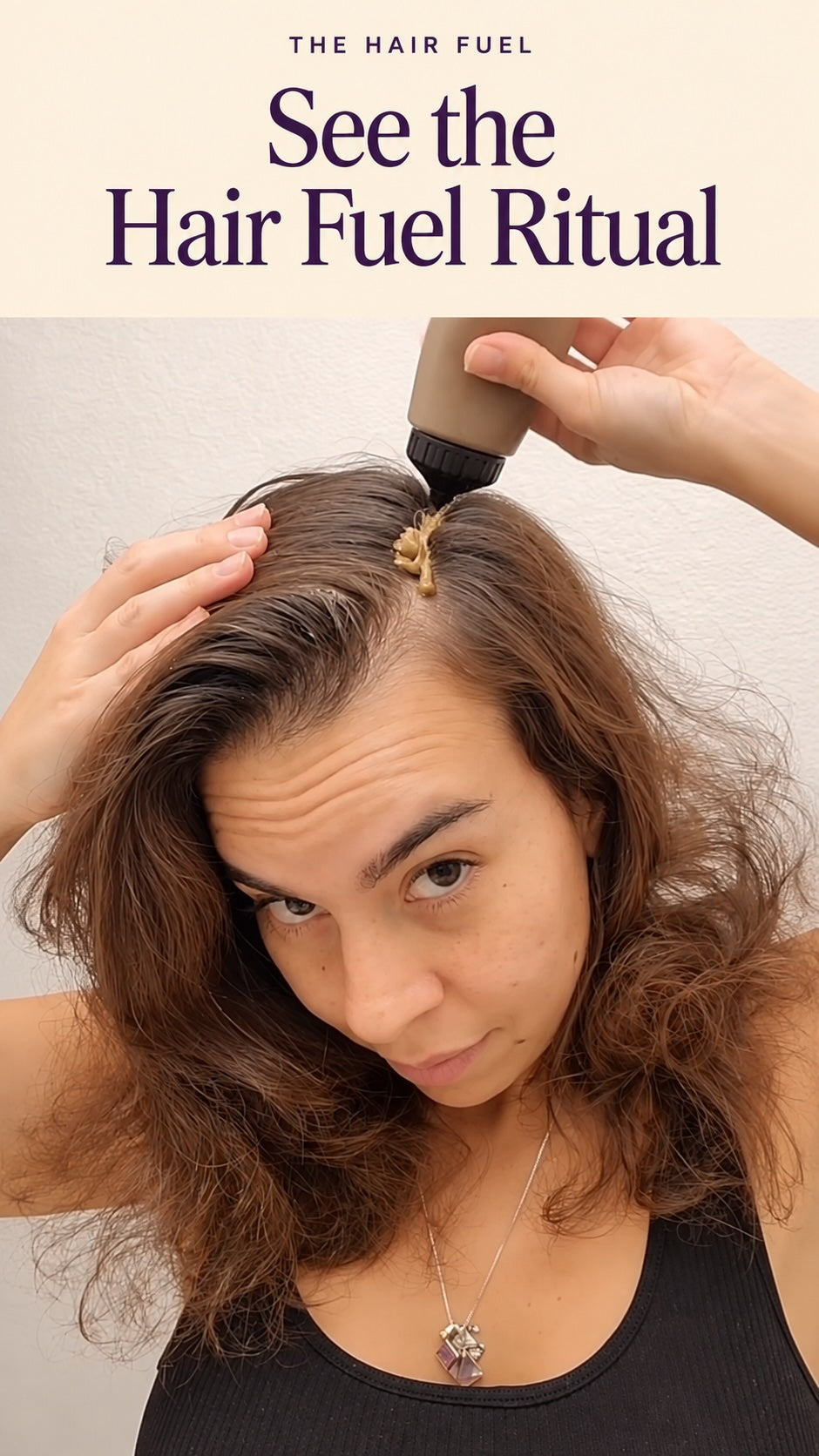 A woman with wavy brown hair looks at the camera while a hand applies a beige hair product from a squeeze bottle onto her hair. Text at the top reads 'THE HAIR FUEL See the Hair Fuel Ritual'.